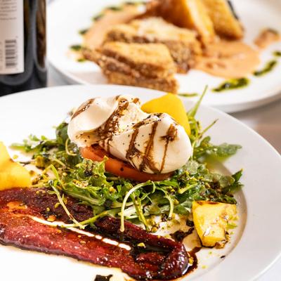 Burrata salad with grilled peaches, arugula, fig jam and balsamic drizzle.