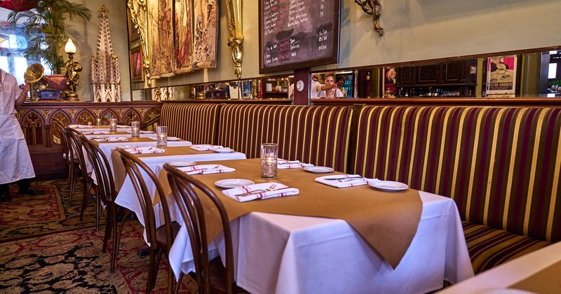 Inside, long banquette seating, tables, chairs, tableware