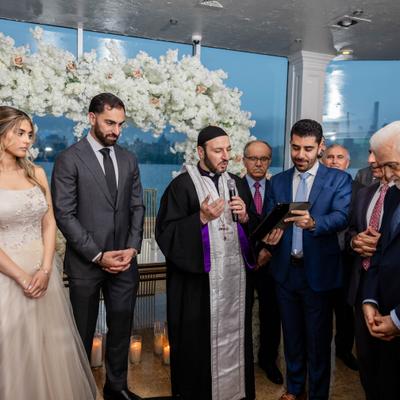 Wedding party gathered around the priest.