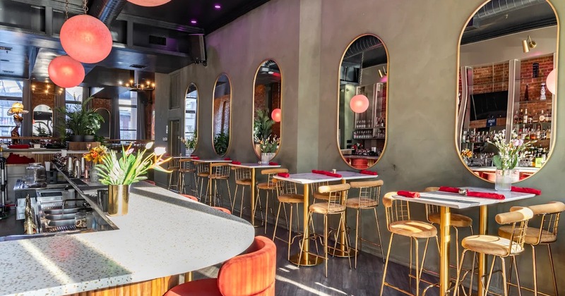 Cozy interior space with high dining tables and stools lined up by the wall across the bar