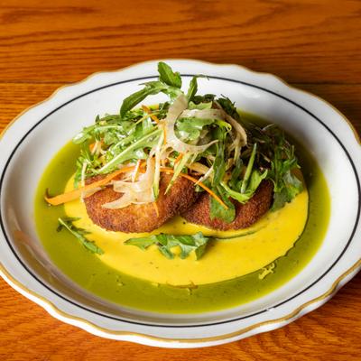 Crab Cakes with lemon saffron sauce, basil infused olive oil, and fennel arugula salad.
