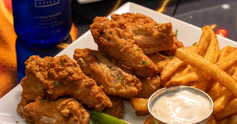 Fried chicken wings with carrots, celery, fries, and dip