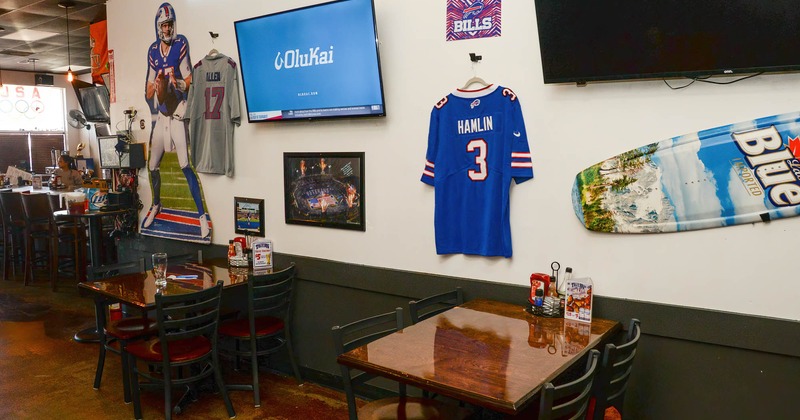 Interior, tables and chairs, framed pictures, jersey and tv screens on the wall