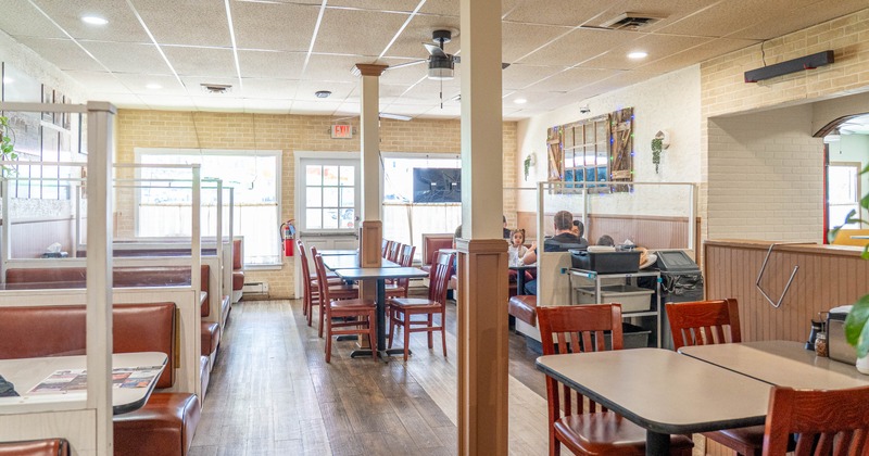 A cozy diner interior with brown leather booths and wooden tables