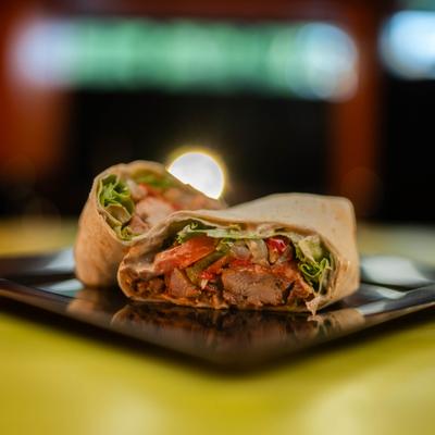 Chicken Wrap served sliced in half on a black square plate.