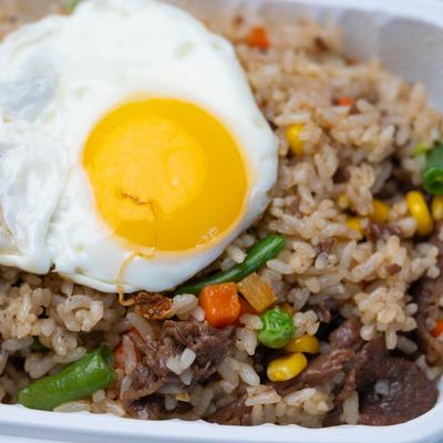 Fried rice beef topped with a sunny side up egg.