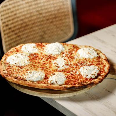 A thin crust white pizza topped with dollops of fresh ricotta cheese.