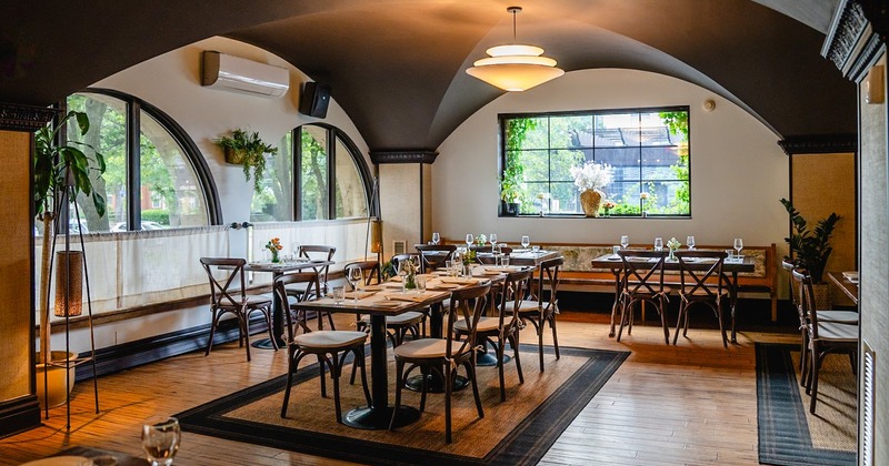 Elegant dining room with wicker chairs around a wooden table set for eight