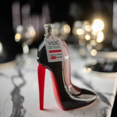 High heel display bottle on a marble table.