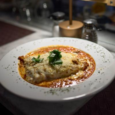 A serving of baked Italian lasagna covered in melted cheese and tomato sauce.