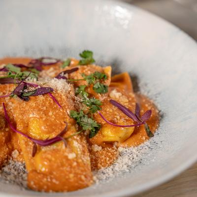 Agnolotti ai Formaggi (V)	 House Made Pasta filled with Leeks, Ricotta, Gorgonzola Tomato Bechamel Sauce.