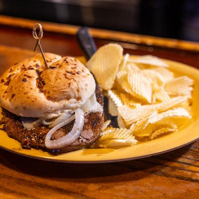 Prime Rib Sandwich with sauteed onions, Swiss cheese and a side of chips.