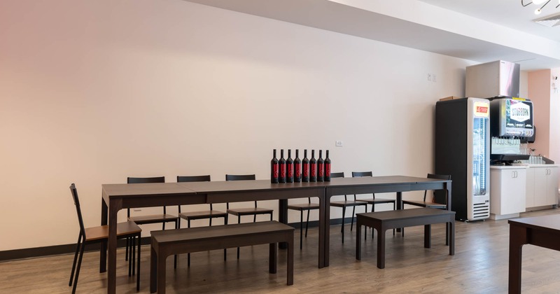 Interior, a long table with bench seating and chairs, wine bottles on the table