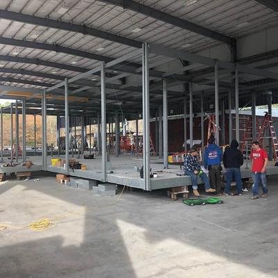 A group of workers standing in the middle of a building interior space