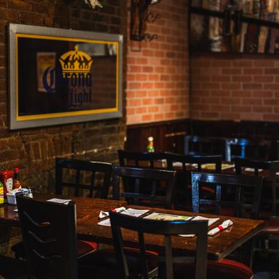 Interior with a brick walls, wooden tables and chairs.