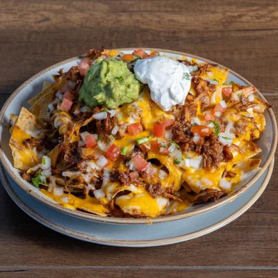 Loaded nachos topped with meat, melted cheese, pico de gallo, guacamole and sour creme.