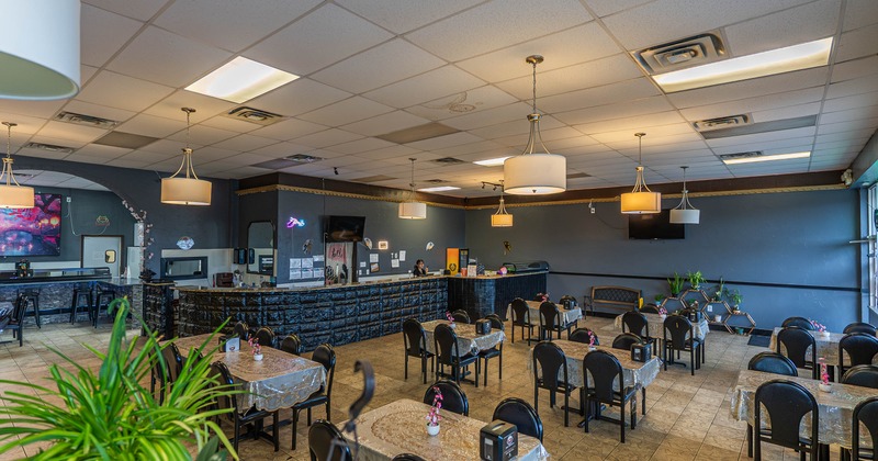 Spacious, restaurant interior with neatly arranged tables and black chairs
