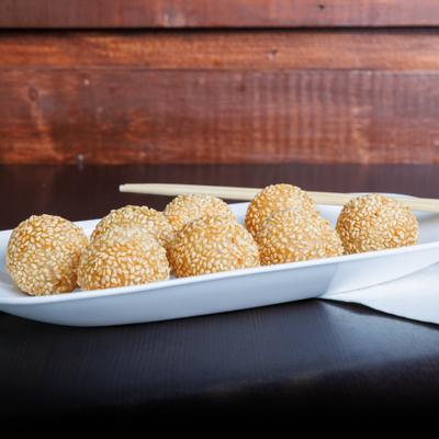 Sesame balls served on a white rectangular plate.