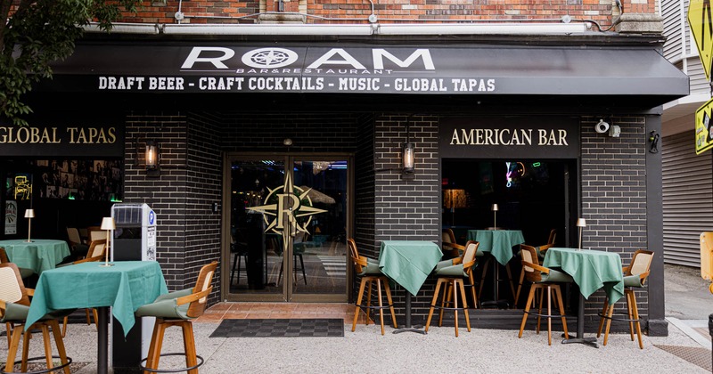 Exterior of the restaurant with outdoor seating and signage for draft beer and global tapas