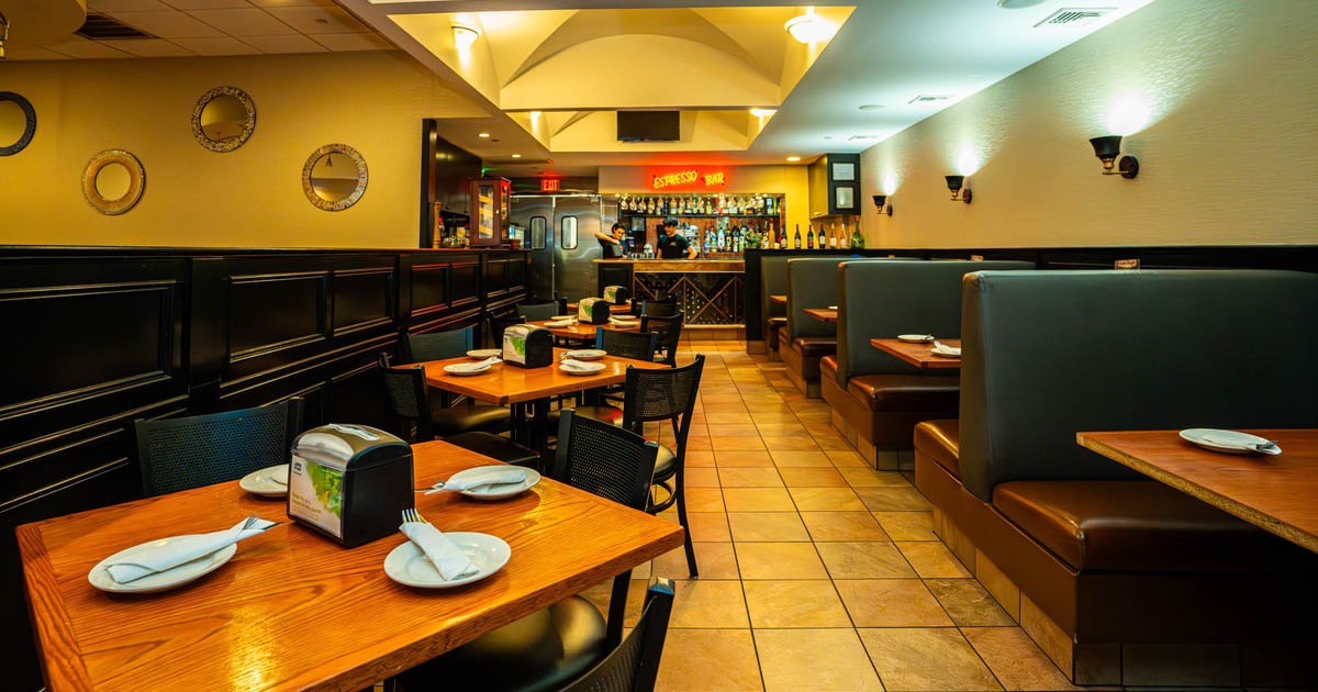 Inside, dining tables and chairs ready for guests, seating booths