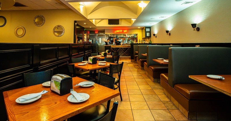 Inside, dining tables and chairs ready for guests, seating booths