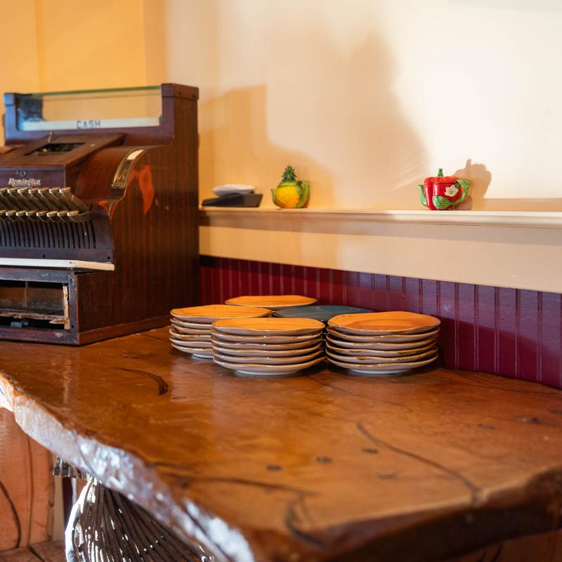 Stacks of plates and a vintage cash register.