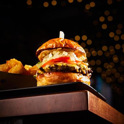 Burger topped with cheese, lettuce and tomato, served with tater tots.