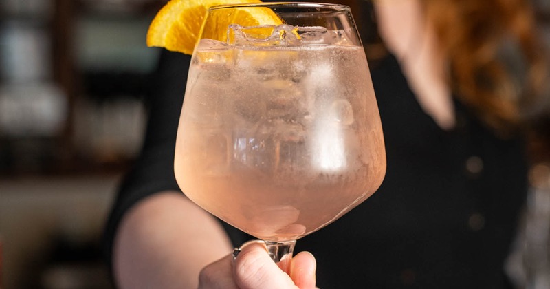 A bartender serves Paloma cocktail