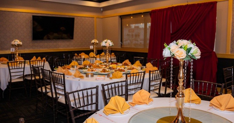 Dining room's interior with tables set with plates, cutlery, napkins and decorations