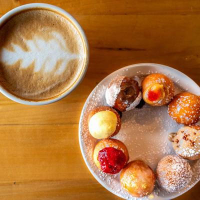 A plate with Doughnut bites and a cup of latte, top view.