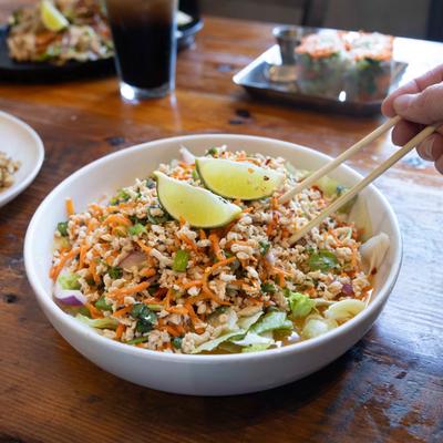 Larb Salad on a table with other dishes in the background.