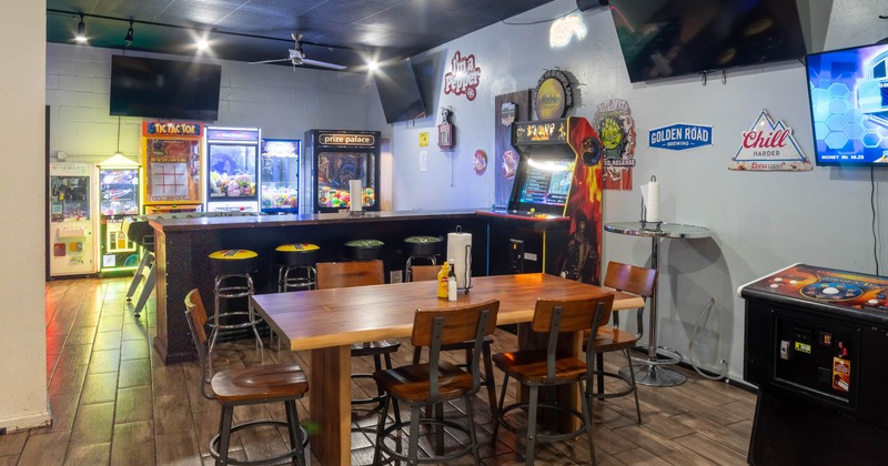 Interior, high seating and bar area, bar with stools, crane games in the back