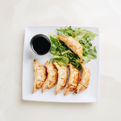 Fried potstickers served with dipping sauce.