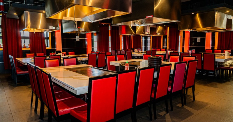 Interior, back to back marble top hibachi tables with padded chairs, tile flooring