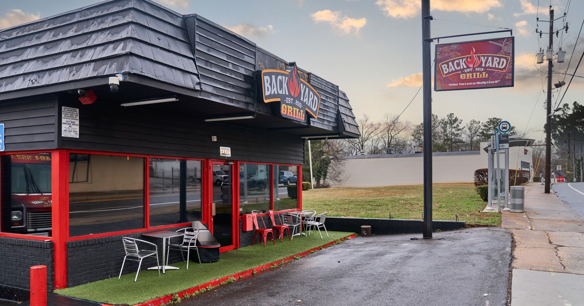 Restaurant exterior with seating area and signs