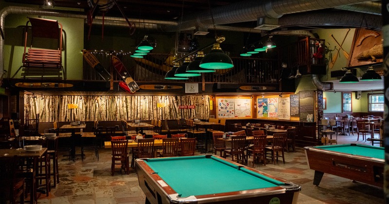 Interior, billiard pool table with tables and chairs in the back