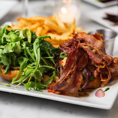 Lobster BLT, arugula and fries on a plate.