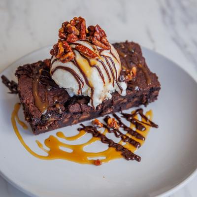 Brownie Sundae topped with vanilla ice cream, chocolate caramel sauces, and pecans