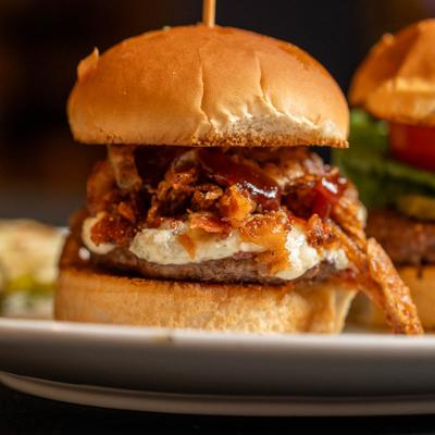 Close up of two gourmet sliders on a white plate.