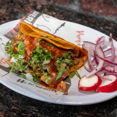 Crispy taco with red salsa, cilantro, onions, and a side of radish and onion.