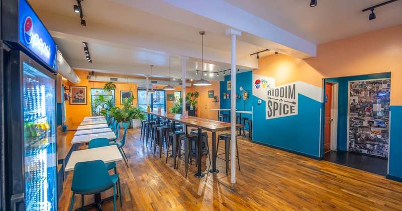 Interior, long high table and chairs, tables and blue chairs on the left