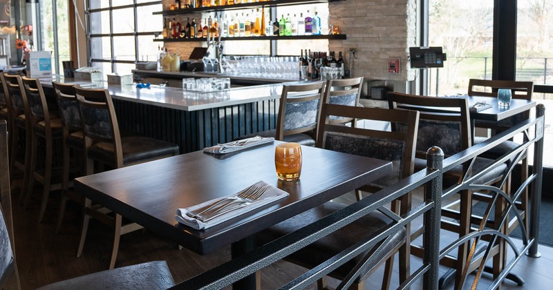 Interior, table ready for guests, bar area in the back