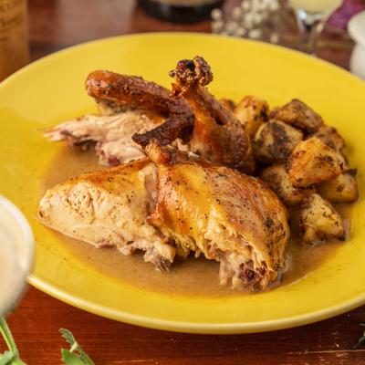Tuscan roasted chicken alongside seasoned potatoes.