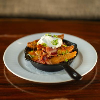 Loaded Potato Wedges, with garlic butter, cheese, bacon, chives, and sour cream.