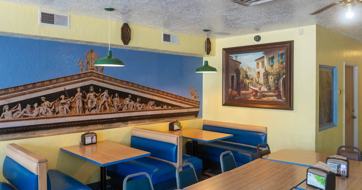 Interior, dining area with booth seating, a classical mural, and a street scene painting