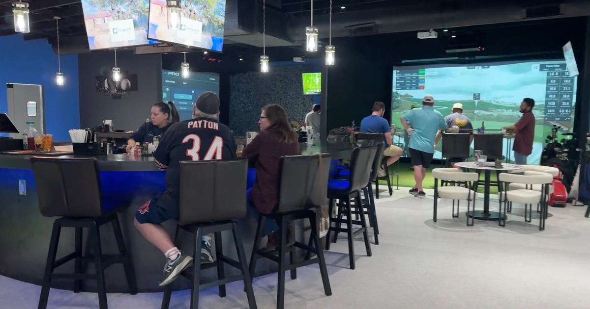 Bar area of a modern indoor entertainment space with a golf simulator