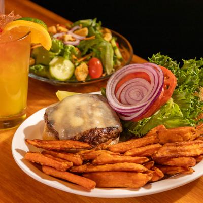 Trailside Burger with sweet potato fries, alongside small salad and a drink.