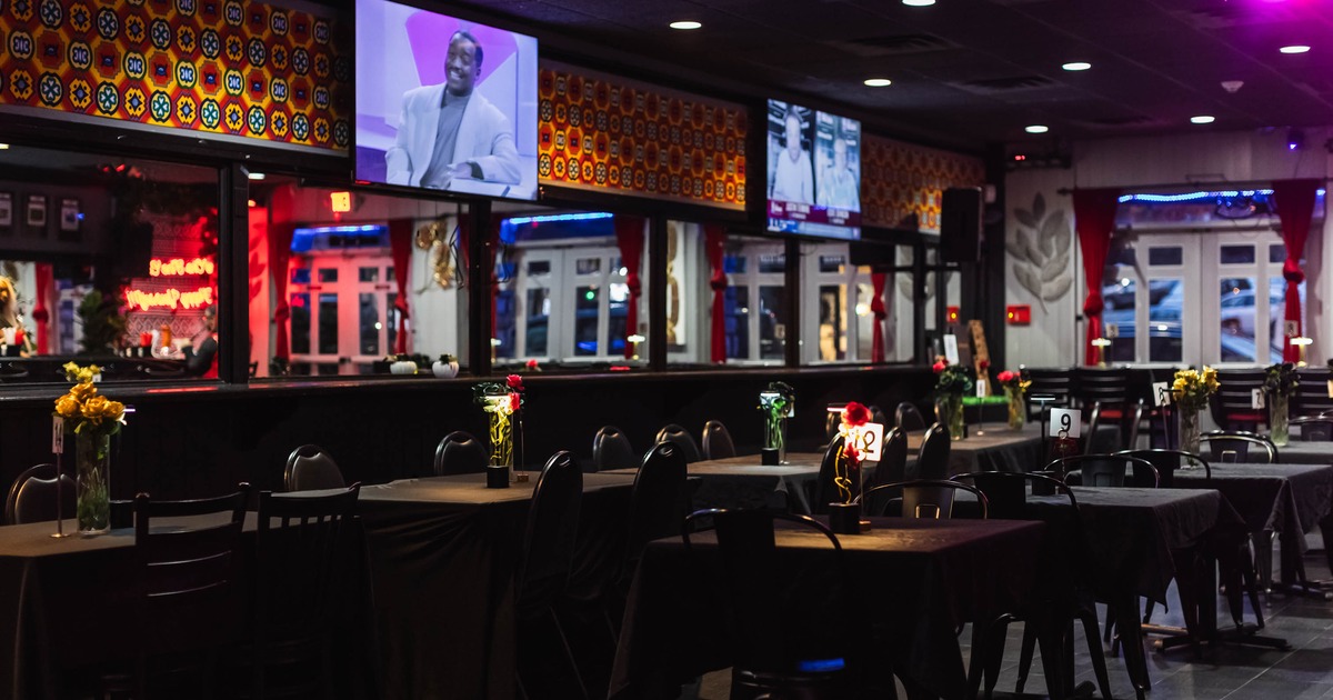 Interior, dining area, tables with chairs ready for guests, large screen TVs on the wall