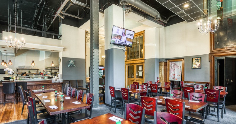 Interior, tables and chairs in dining area with bar in background