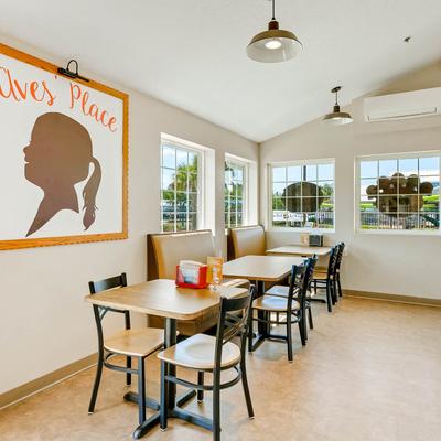 Bright restaurant scene with tables and chairs arranged near windows.